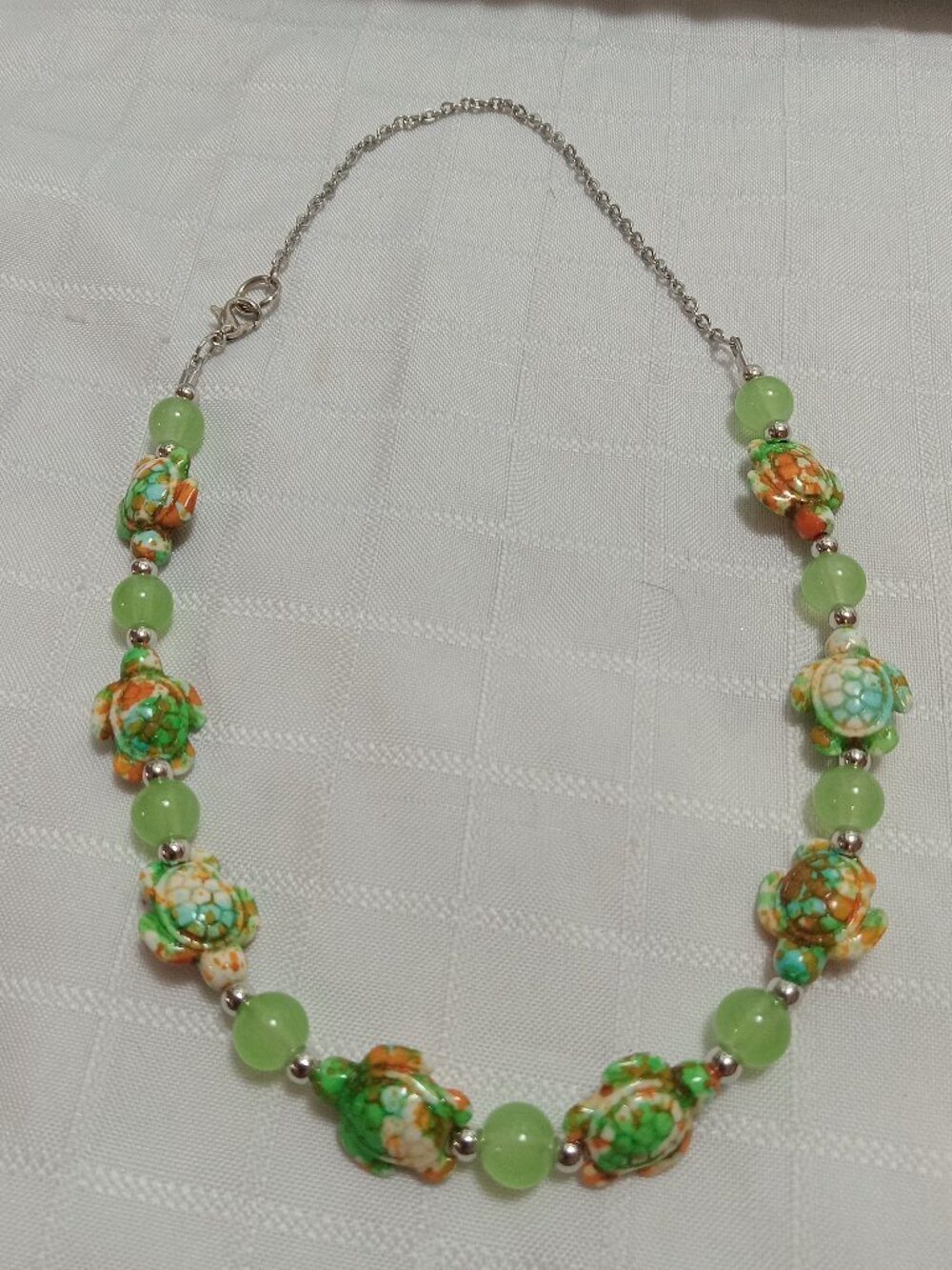 Pretty handmade necklace with little turtles and glass bead